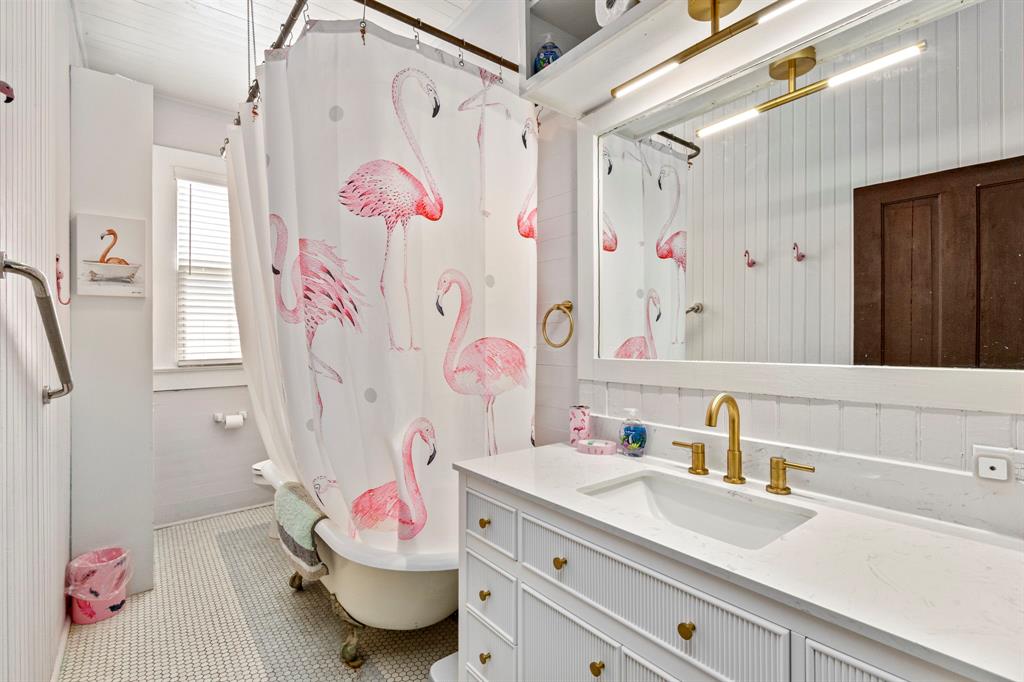 STUNNING claw foot antique tub with penny tile floor and new quartz countertop, sink and trendy gold tone faucet and light above!