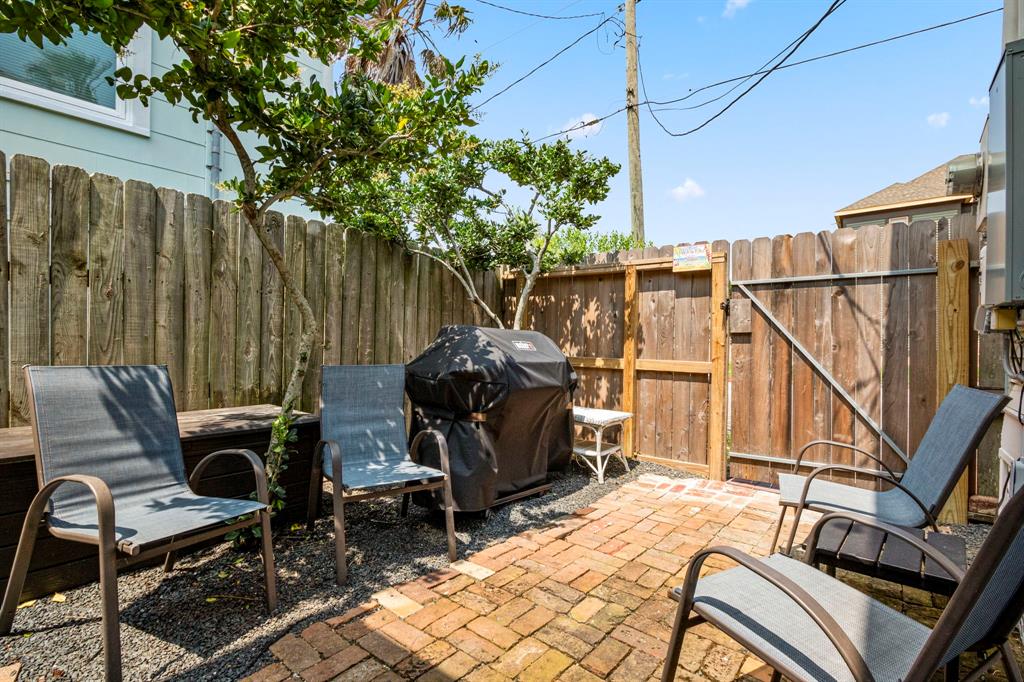 The side yard area has room to gather and a grill for your guests!