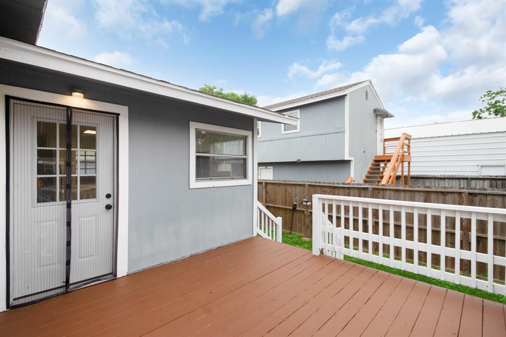 Spacious deck in the backyard with new stained pressure treated wood flooring and freshly painted railing.