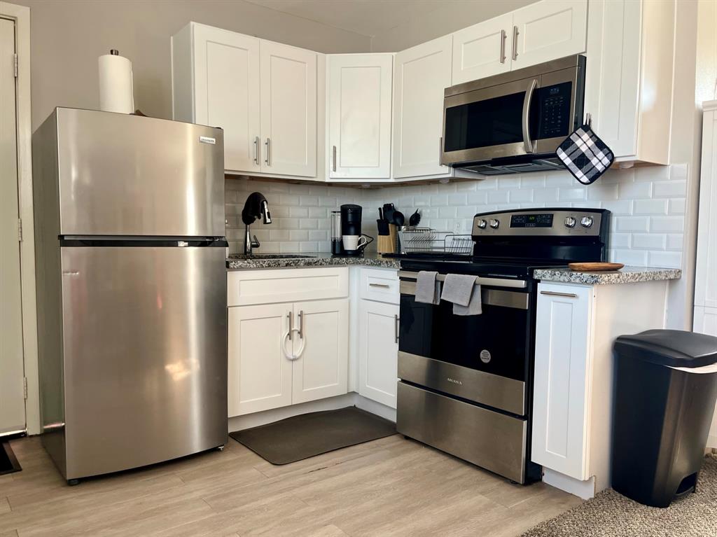 Updated kitchen with granite countertops, new cabinetry, and appliances.