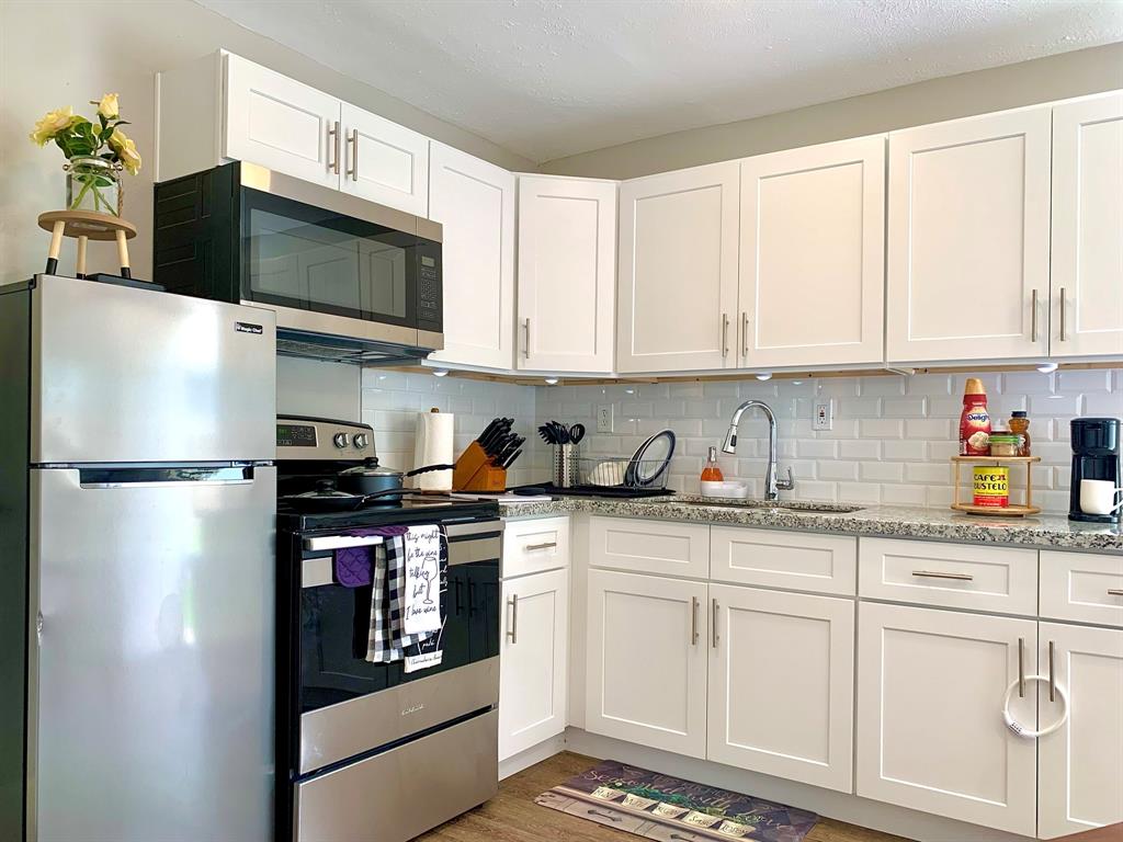 Kitchen features new granite countertops and cabinetry.