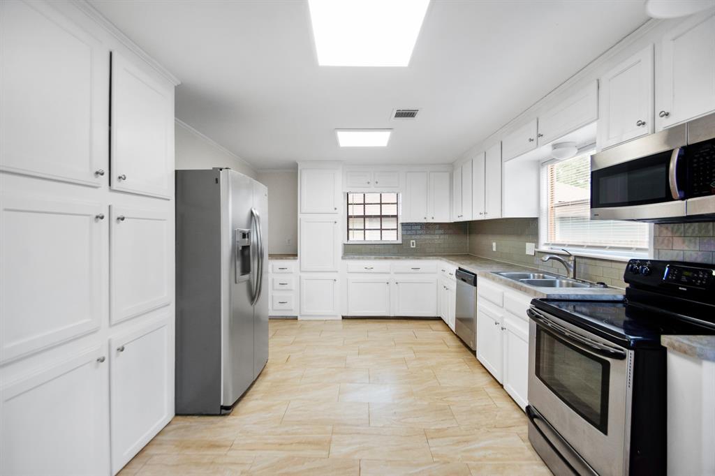 This kitchen features sleek stainless steel appliances, adding a modern touch to the space.