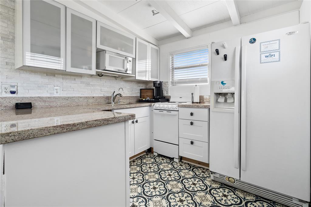 THIS BEAUTIFUL KITCHEN FEATURES UNIQUE FLOORING, AMPLE STORAGE SPACE AND GRANITE COUNTERTOPS.