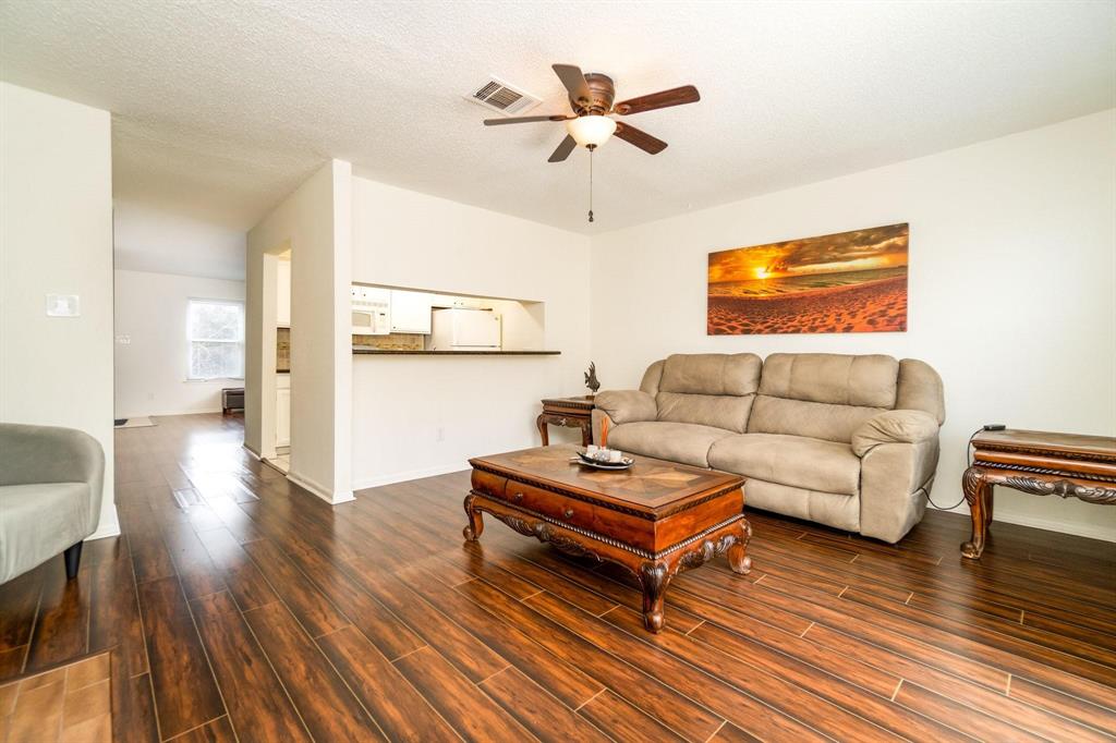 View of your formal living room next to kitchen and flex room. You do have a half bathroom downstairs for your guests.