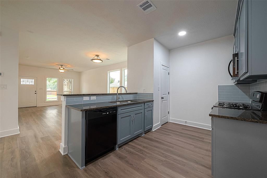 The kitchen offers a breakfast bar, plenty of cabinet space, double sink and sleek countetops.