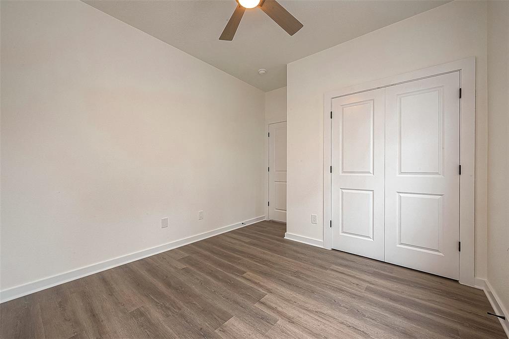 Bedroom #3 in the home has a ceiling fan and neutral painted walls.