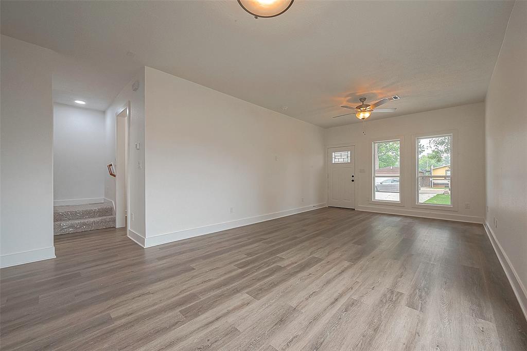 The living area features laminate flooring, ceiling fan and has plenty of natural light!