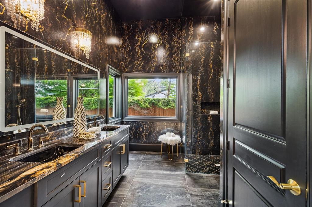 A stunning primary bathroom suite with hand painted walls and seamless glass shower.