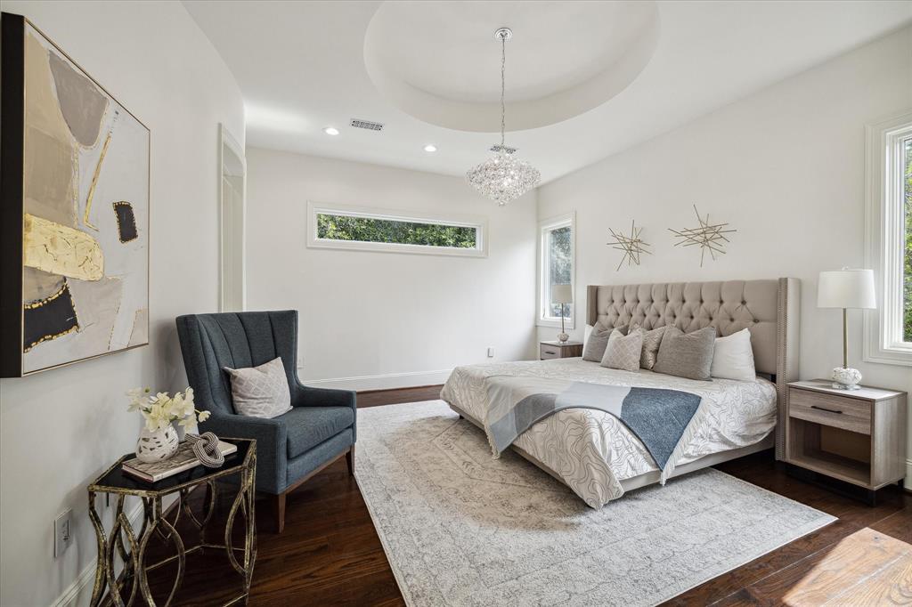 Upstairs primary suite with ceiling detail and flooded with natural light.