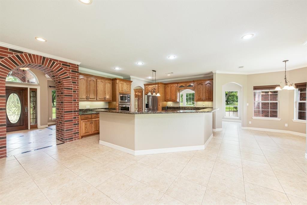 The open concept allows you to stay in touch with family and guests while entertaining. To the right is the large breakfast area and beyond the arched doorway on the right is the second living area.