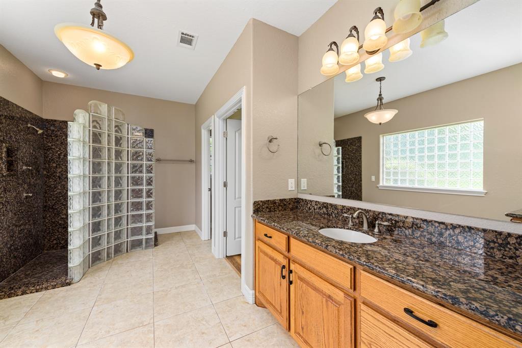 The spacious spa like primary bath is absolutely stunning. Very large granite and glass block shower walk through shower. No detail was spared in creating this lovely space.