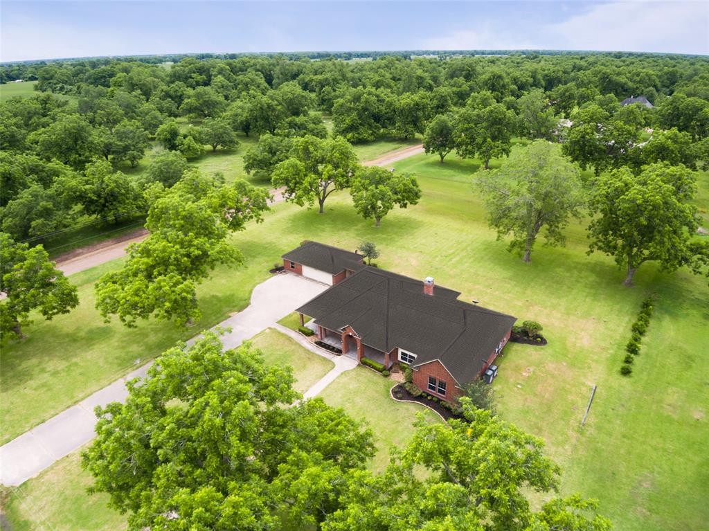 Aerial of the front of this gorgeous home reflects the  size of this property, beautiful acreage and surrounding countryside.