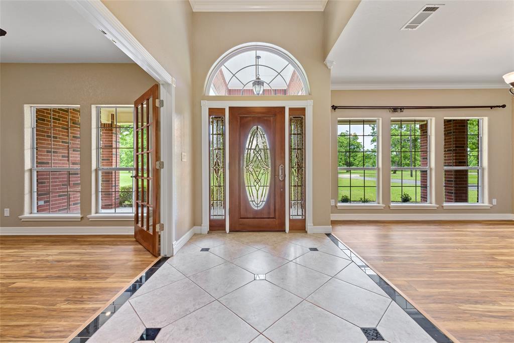 Impressive welcoming foyer to greet your guests. Leaded glass doors,sidelites and arched transom window allow natural light to flow into this beautiful space.Note the beautiful floors.