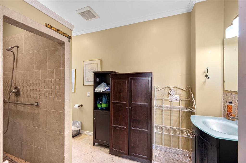 Beautifully updated primary en-suite bath features a large tile shower. Coordinating tile floor and tile backsplash.