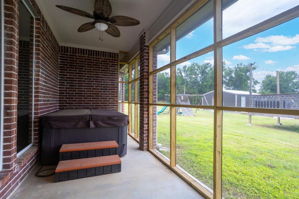 Screened in porch with hot tub and ceiling fan