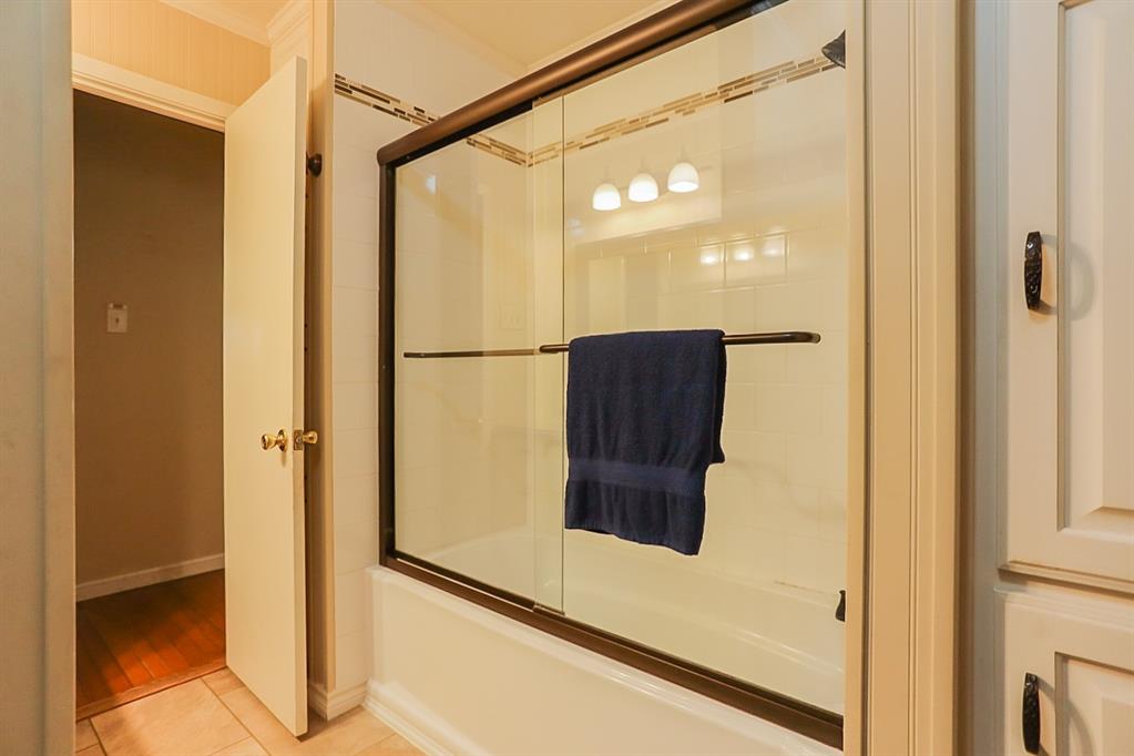 Full bathroom with tub/shower and sliding glass doors.