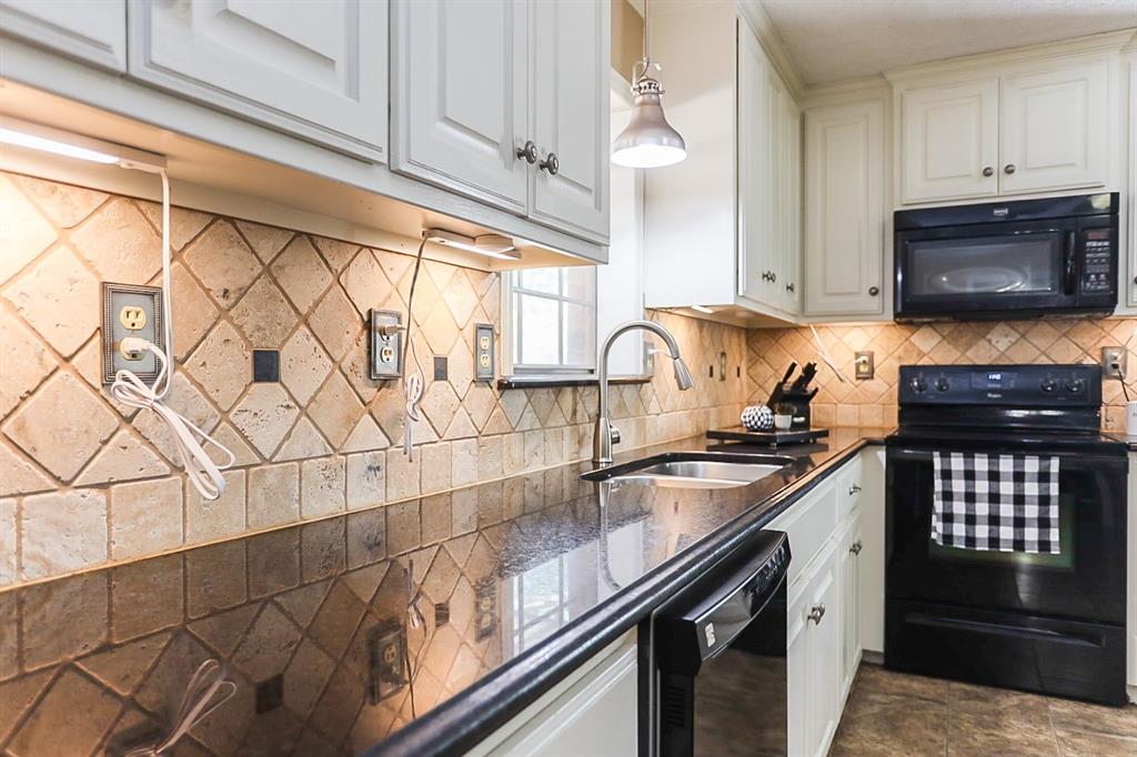 Travertine backsplash and granite diamond with under counter lighting.