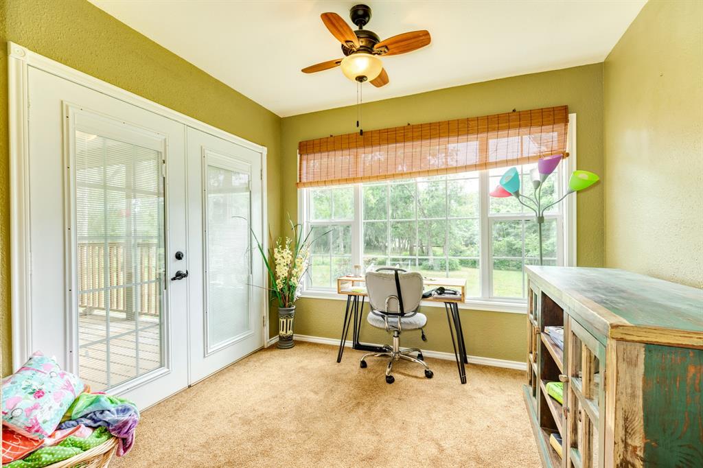 Sitting room off of the primary bedroom, with double doors leading out to a private porch.