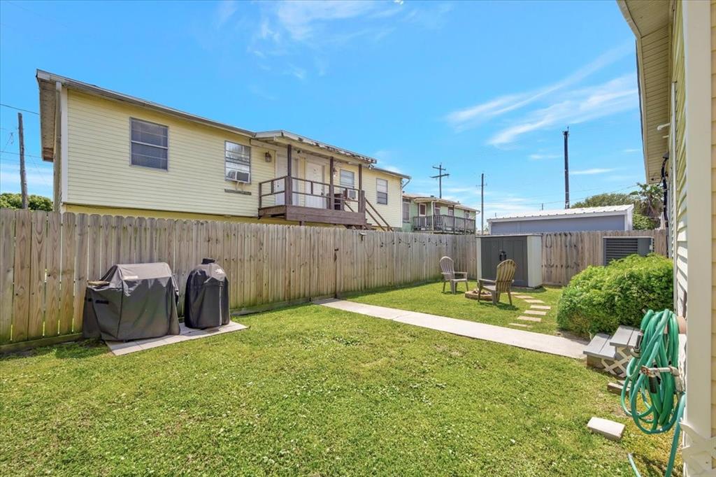 Spacious backyard of the front home. Room to barbecue sit out by the fire pit and enjoy Galveston breezes.