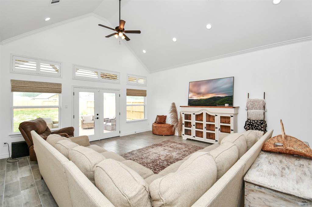 Living room with windows and doors opening to covered patio