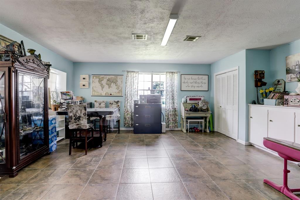 Spacious room with cabinets,  featuring a blue wall and tiled flooring.