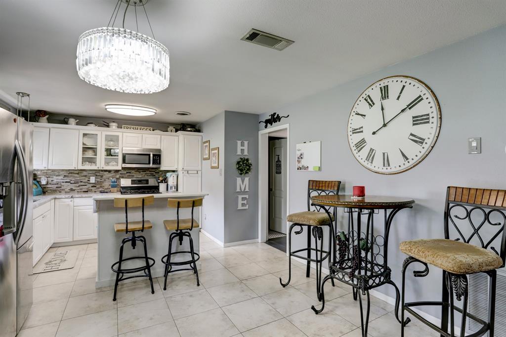 A well-lit kitchen with white cabinets and modern appliance