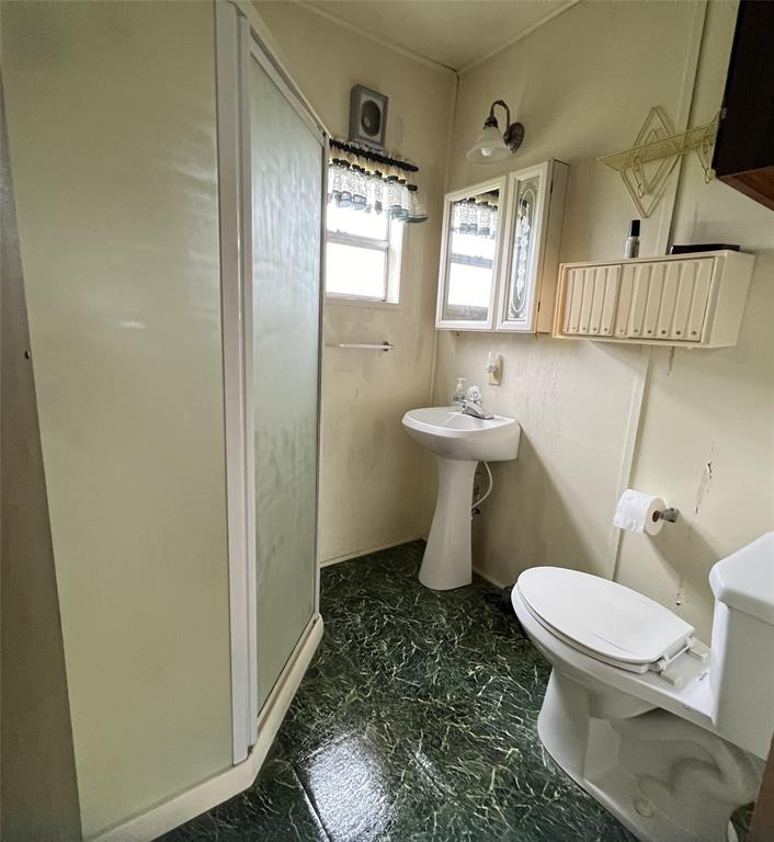 Bathroom with shower and pedastal sink.