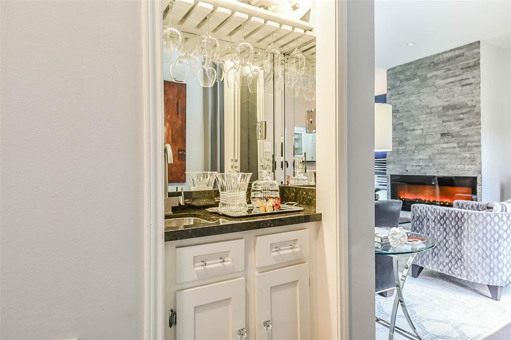 Beautiful granite wet bar with storage for wine glasses.