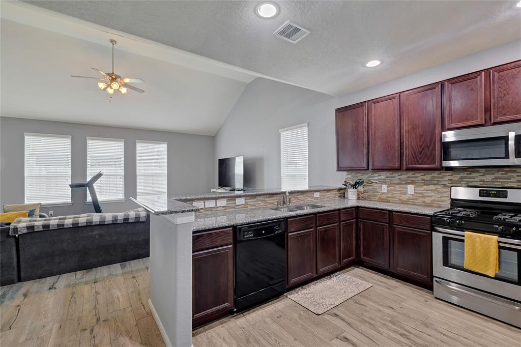 This gourmet kitchen boasts of granite counter tops, stainless appliances, dark cabinets and a fabulous backsplash.