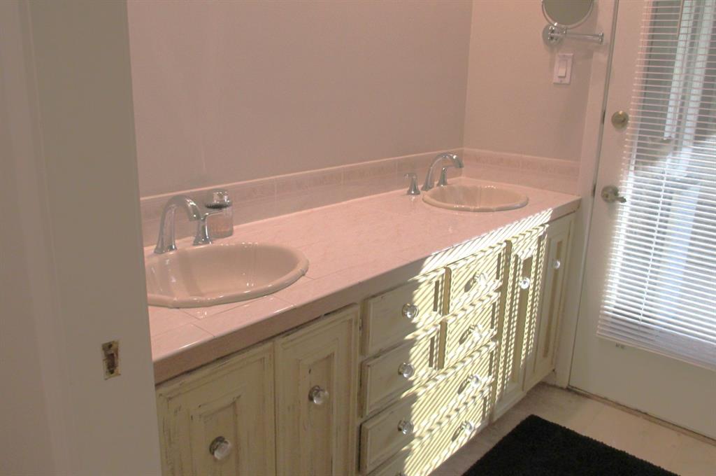 Guest bath with double sinks, loads of drawers and access to the backyard patio.