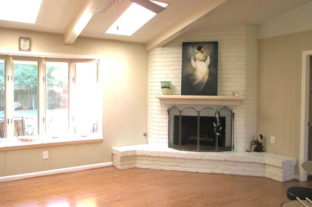 Family room offers gas log fireplace, mantle, windows galore and skylights