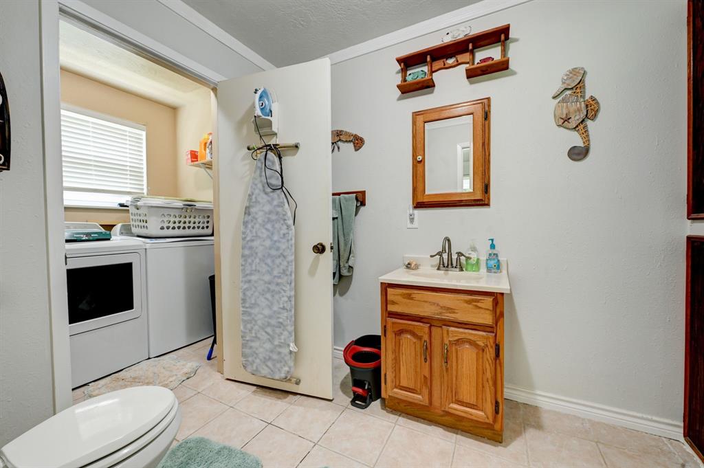 Secondary bathroom with laundry room.