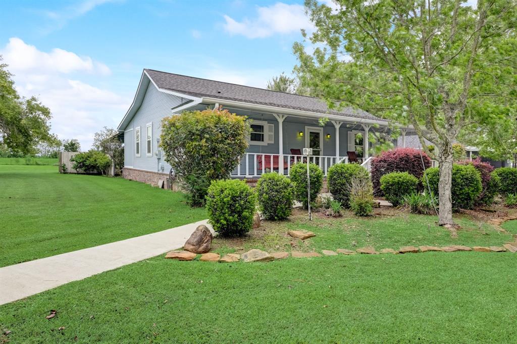 Expansive front porch and lush landscaping create an inviting space to sit and relax.