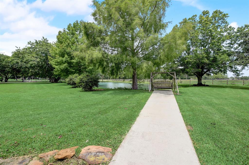 Pathway to the fully stocked pond. Enjoy fishing in your front yard or just feeding the fish.