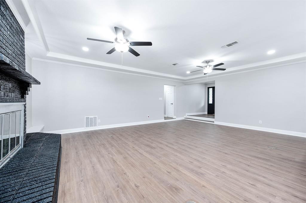 HUGE family room accented with this BEAUTIFUL black brick fireplace and BEAUTIFUL waterproof laminate flooring.