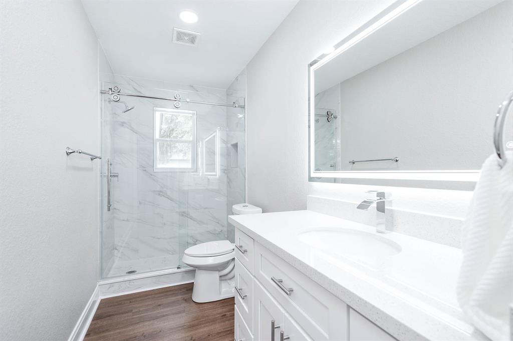 Guest bathroom with the touch mirror lighting and beautiful tile shower.