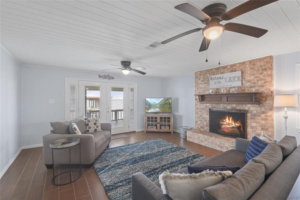 Huge living area with wood burning fireplace and French doors out to the porch and lake