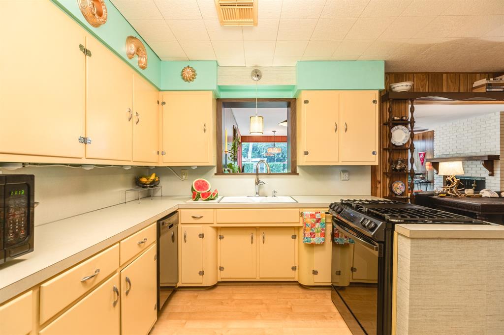 Kitchen large sink new appliances gas cooktop open view to dining room and family room