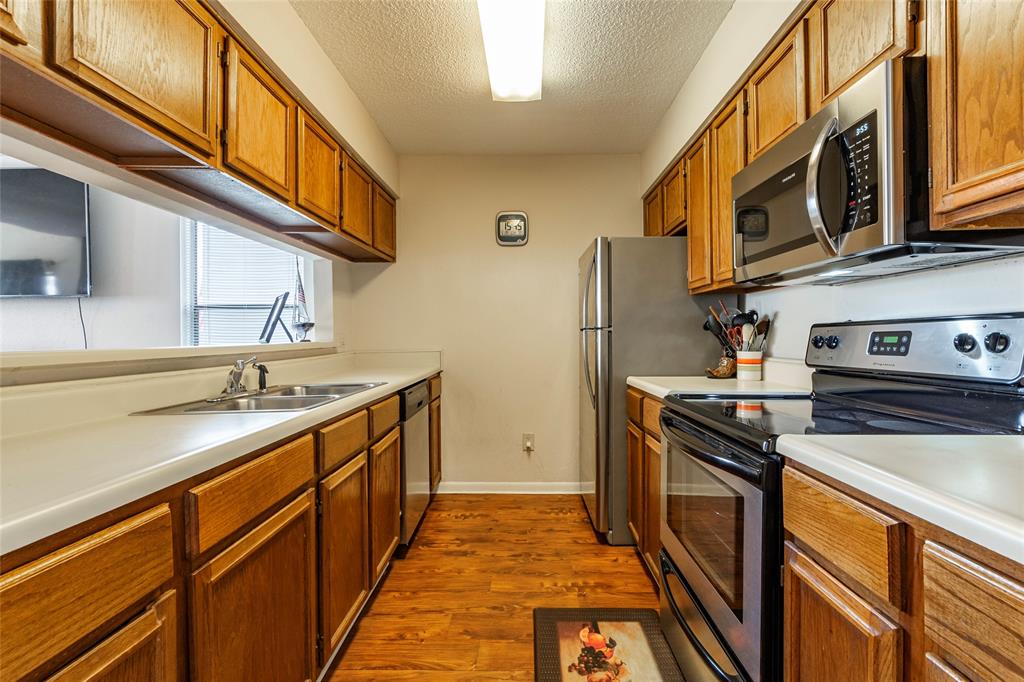 The kitchen is equipped with stainless steel appliances and a refrigerator that stays.