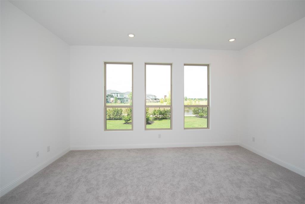 Primary bedroom located at the back of the home with large windows and lake views.