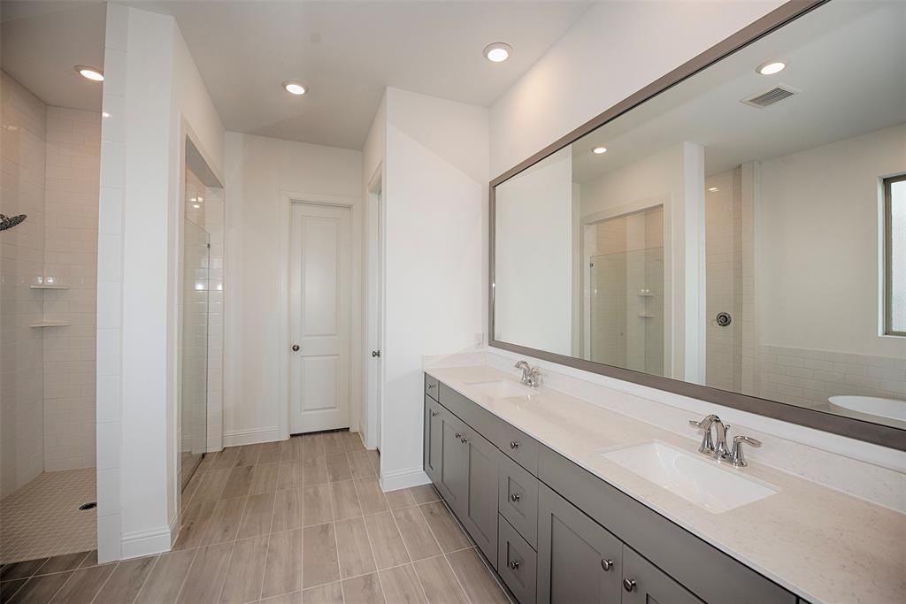 The En Suite bathroom has the gorgeous luxury vinyl floors, double vanity with amazing storage, huge mirror and provides both a large walk in shower and amazing stand alone tub.