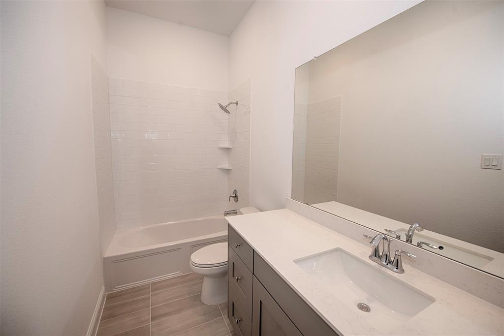 Additional bathroom with large vanity and combo bath and shower.