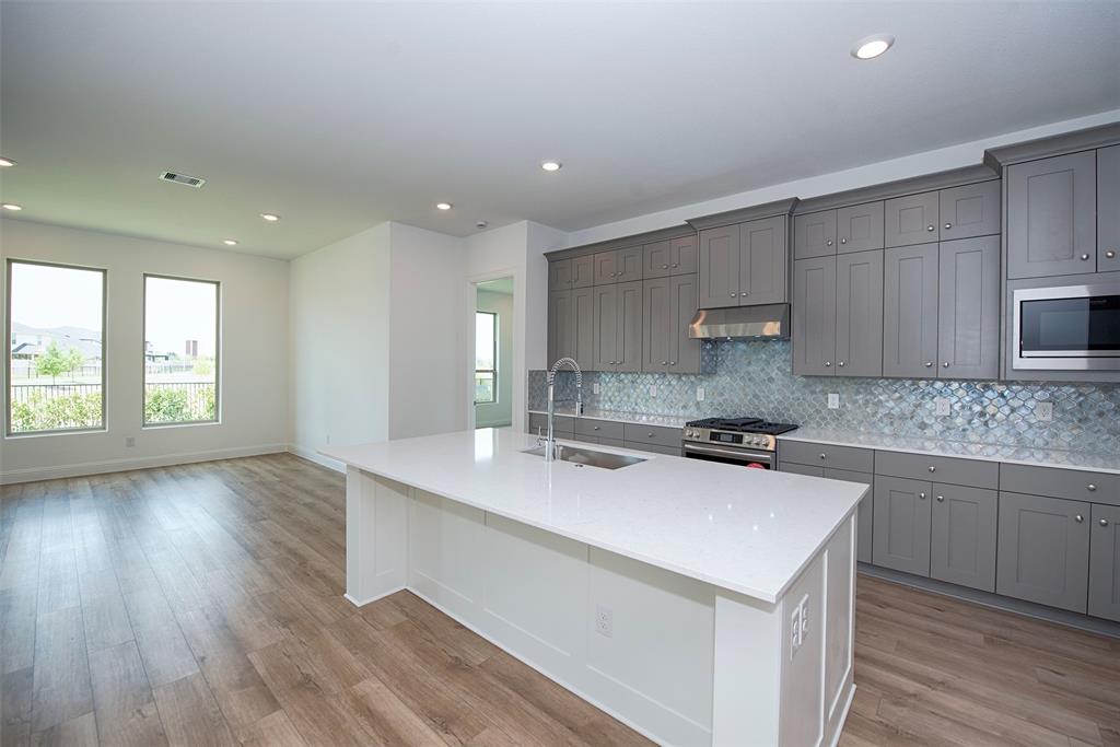 Entry from the foyer to the gourmet kitchen with fabulous island and breakfast bar. Kitchen has quartz counters and fantastic storage.