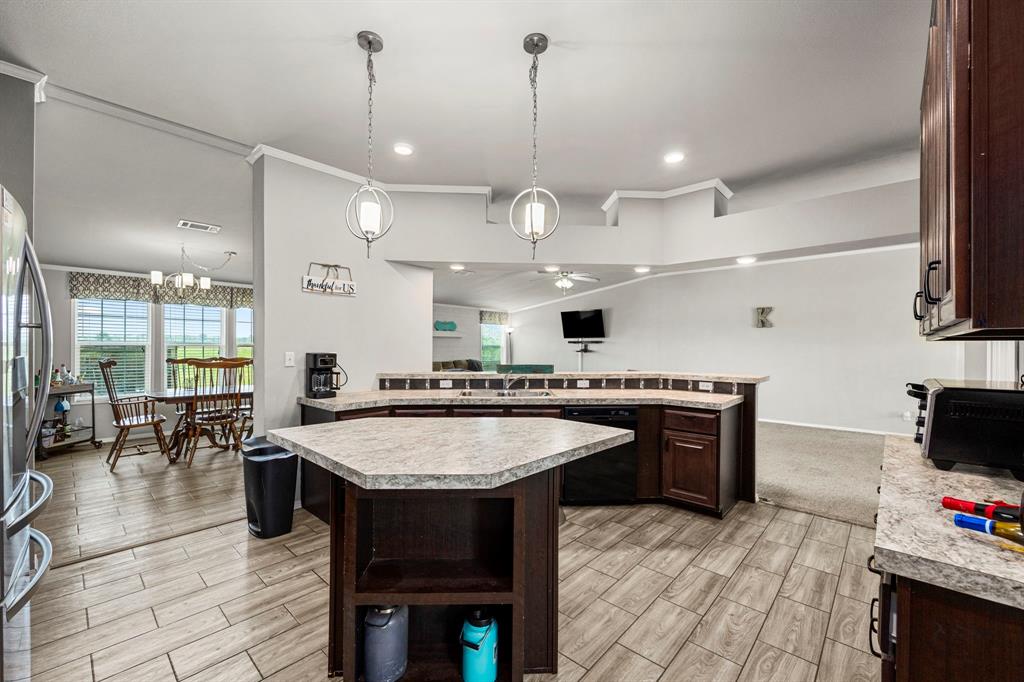 Glass front cabinets let\'s all your guests see your fine China and fancy glassware! Look at all the countertop space and large double basin sink! To the left you can see the Front entry door and the kitchen leads into the multi-use flex space between bedrooms 2&3