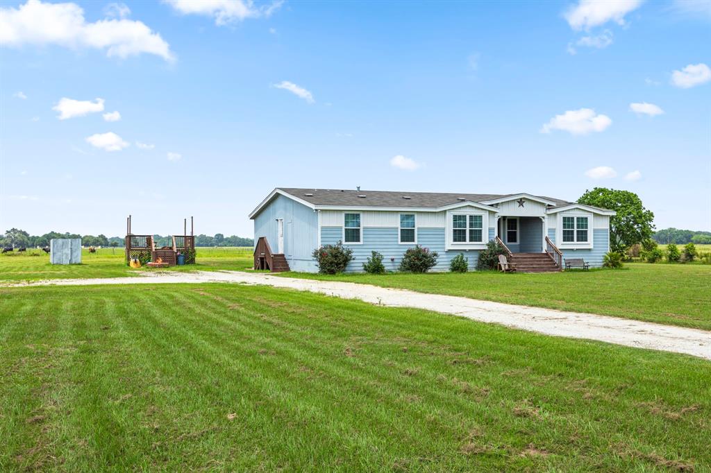 Wooden covered porch greets you and your guests to a country life in Waller!