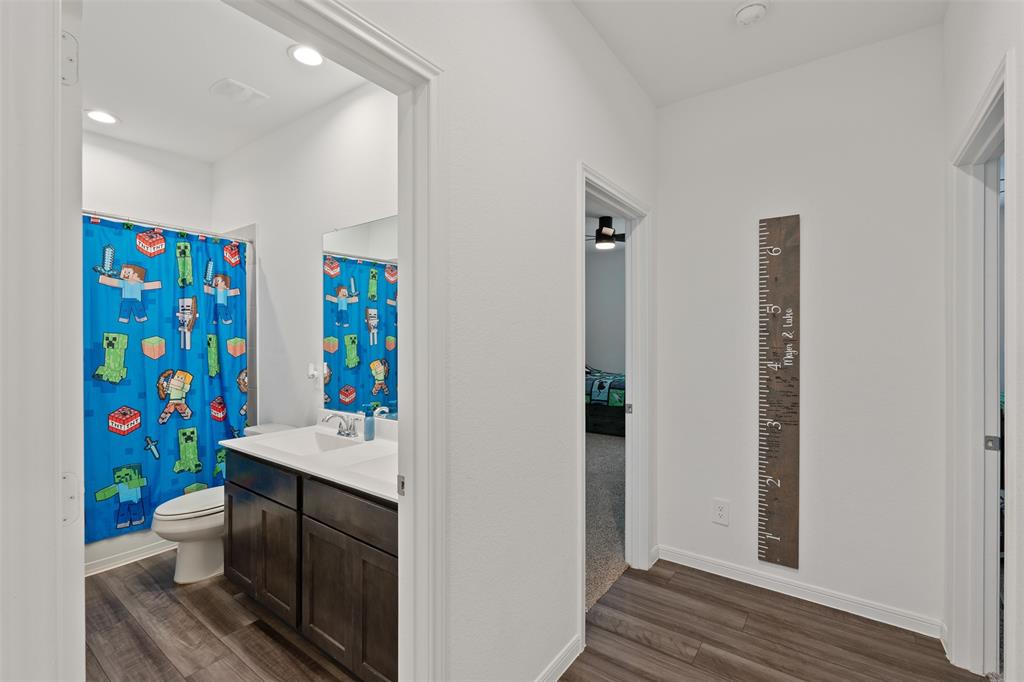 Bathroom 3 located in the hallway with Bedrooms 2 and 3 and across from Laundry room