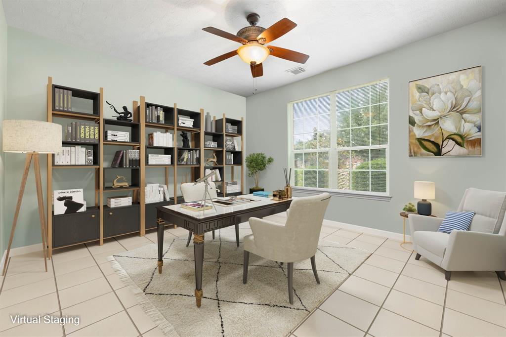 Nestled away quietly in the front of the home is the handsome and grand home office. Featuring dark stained ceiling fan, custom paint, large tile flooring and large windows with privacy blinds.