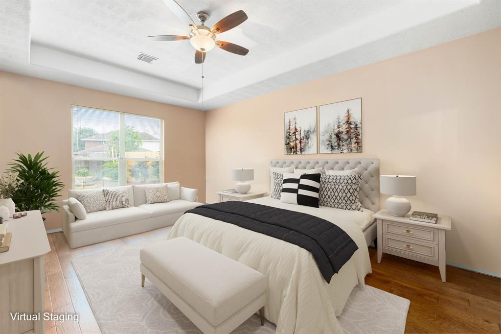 What a wonderful place to come home to, this stunning primary suite greets you with gorgeous wood floors, custom paint, high trey ceilings, ceiling fan with lighting, large windows with blinds allowing in natural light brightening up this spacious primary bedroom, with extra space for a seating area.