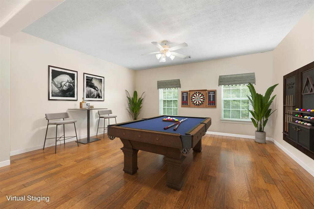 Come upstairs and enjoy a day of leisure in this fabulous game room! This is the perfect hangout spot or adult game room, this space features wood floors, white ceiling fan and custom paint.