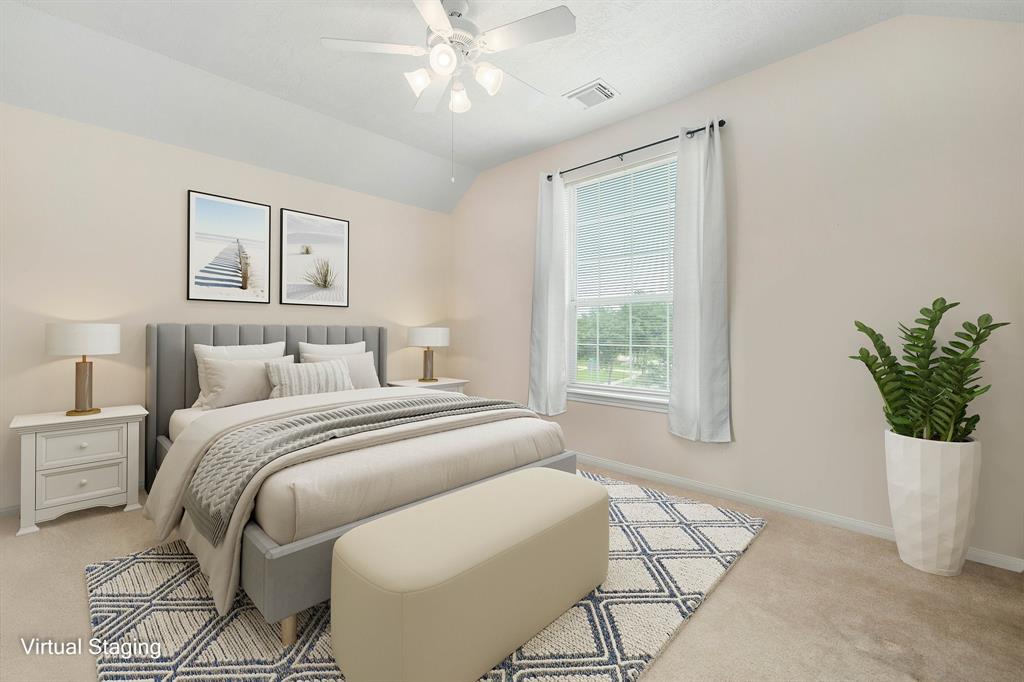 Secondary bedroom features plush carpet, custom paint, white ceiling fan with lighting and a large window with privacy blinds.